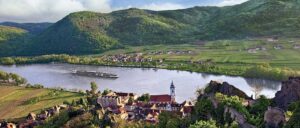 Aerial view of a Viking river ship sailing past Dürnstein, Austria along the Danube river