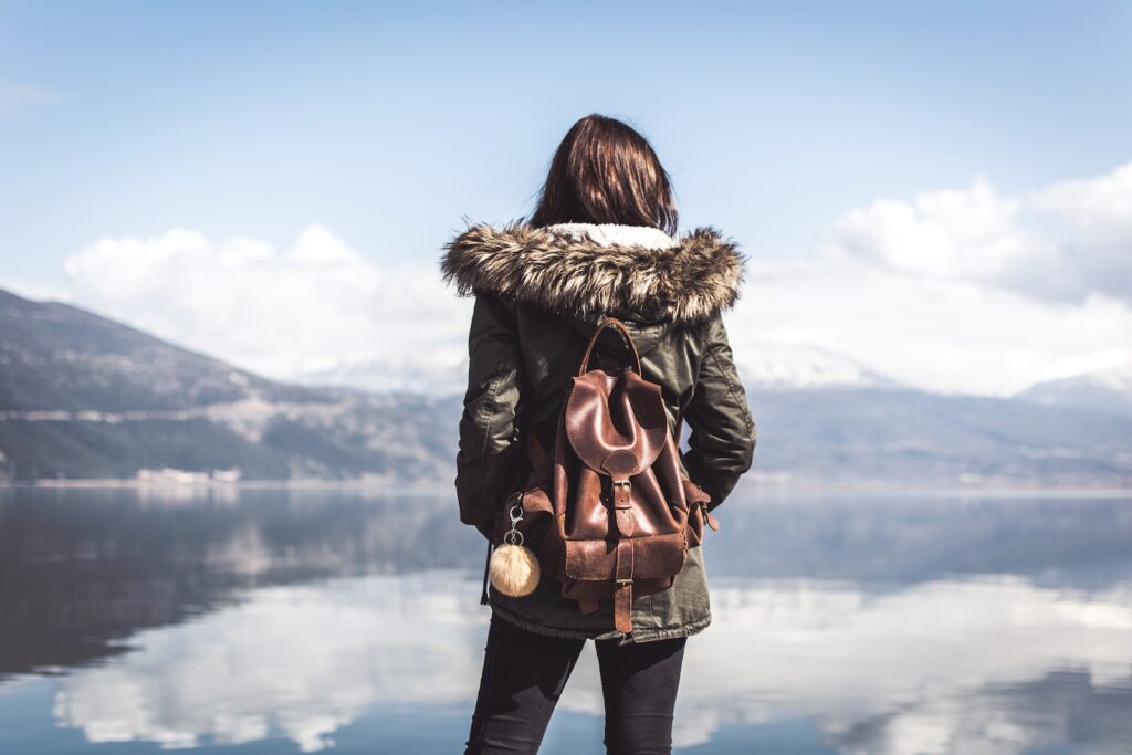 woman facing body of water while traveling