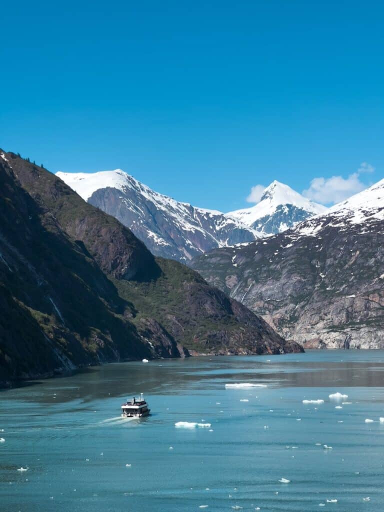 a boat floating on top of a lake surrounded by mountains