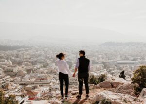 adventurous couple looking at each other with town in background