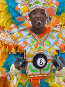 man wearing white, green, and orange costume with number 8 tag