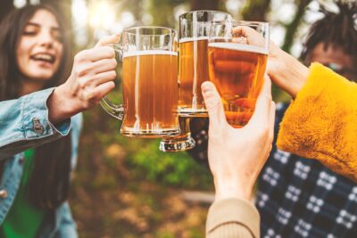 Closeup of friends toasting beers in the farmhouse pub